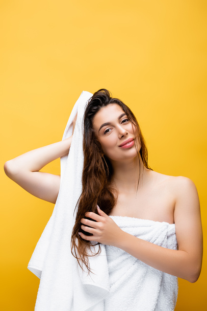 sorrindo bela mulher com cabelo molhado e toalha isolada no amarelo - Foto, Imagem
