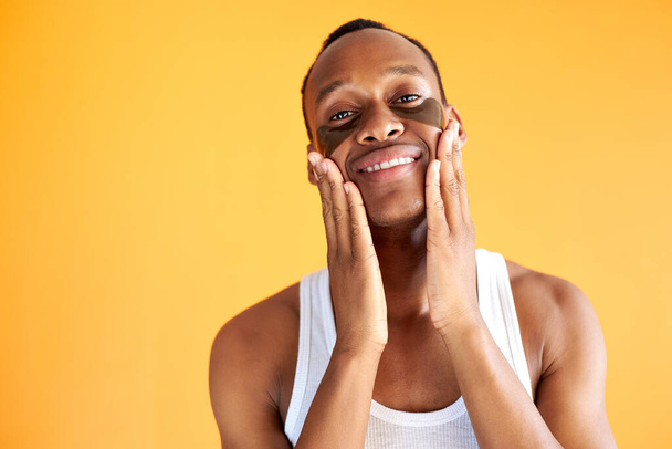 portrait of smiling african american man with black hydrogel patches under eyes - Φωτογραφία, εικόνα