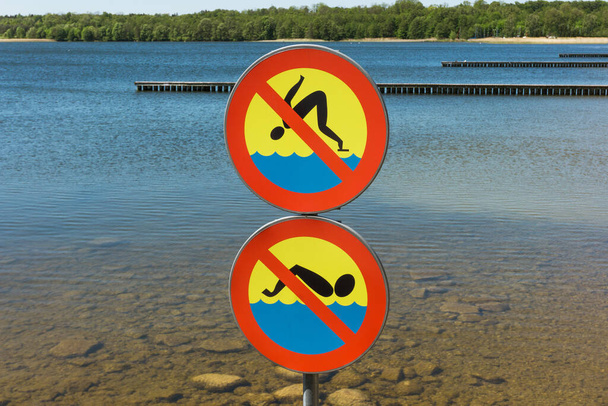 Δεν έχει πινακίδα για κολύμπι. Απαγορεύεται το άλμα στο νερό. Περιορισμοί ασφαλείας στη λίμνη. Ρηχό περιβάλλον κινδύνου νερού. - Φωτογραφία, εικόνα