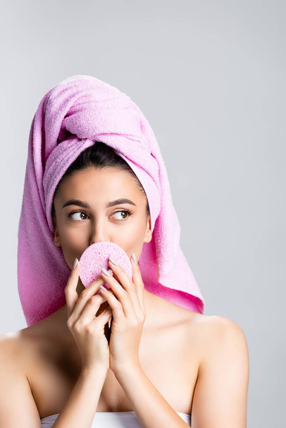 beautiful woman with towel on hair holding sponge isolated on grey - Photo, Image