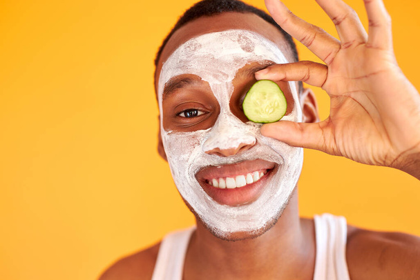 portrait of happy crazy man enjoying face mask with slice of cucumber - Fotografie, Obrázek