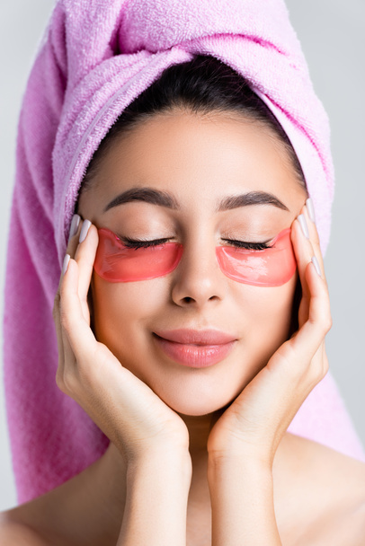 beautiful woman with towel on hair and hydrogel eye patches on face isolated on grey - Photo, Image
