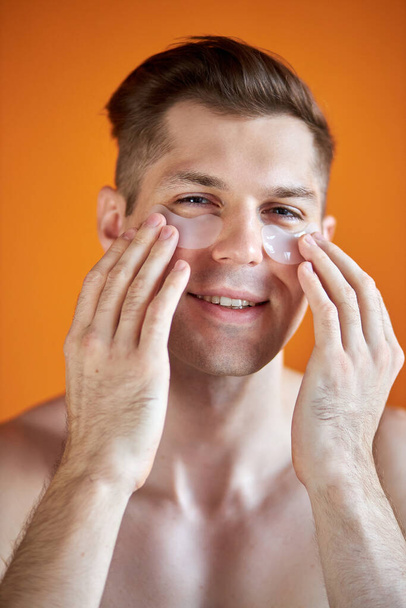 portrait of handsome caucasian guy with transparent patches for dark circles under eyes - Foto, Bild