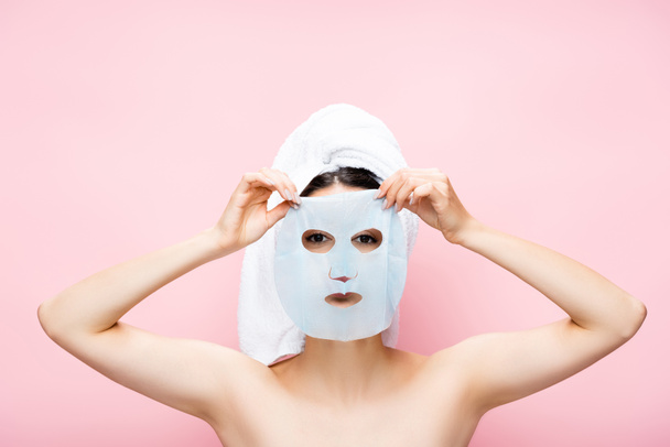 hermosa mujer con la hoja de máscara en la cara aislada en rosa - Foto, Imagen