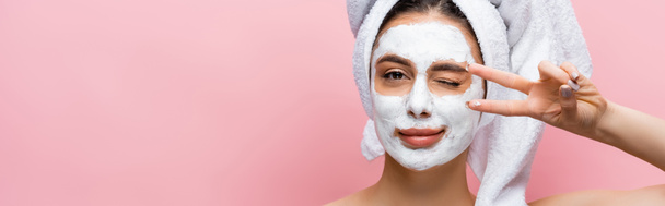 beautiful woman with towel on head and clay mask on face grimacing isolated on pink, banner - Foto, Imagem