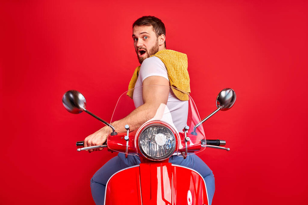 young shocked male sit backwards on motorcycle - Zdjęcie, obraz