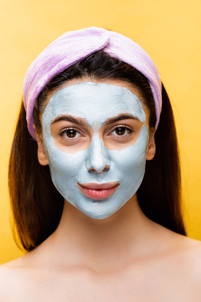 beautiful woman with clay mask on face isolated on yellow - Photo, Image