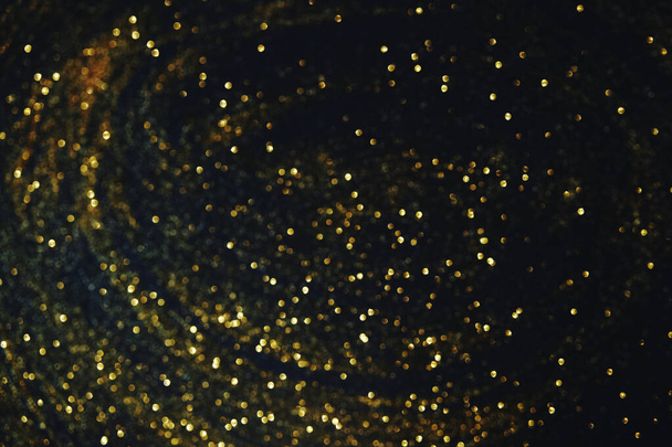 paillettes d'or sur fond abstrait bleu foncé bokeh lumière déconcentrée. - Photo, image