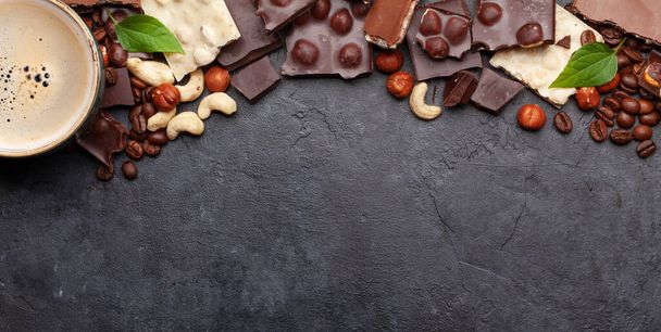 Various chocolate pieces, coffee and nuts on stone table. Top view flat lay with copy space - Foto, Imagen