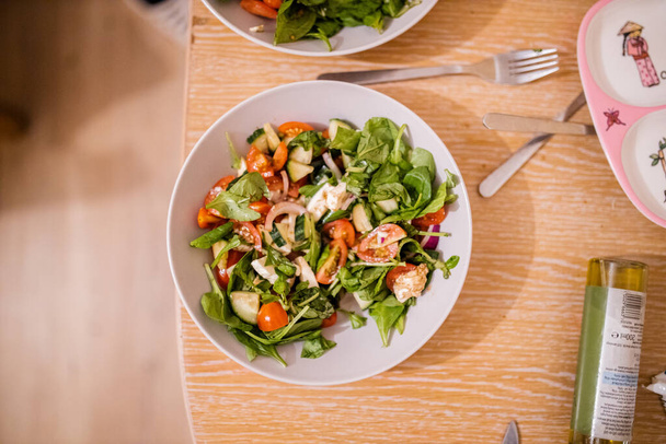 Чаша салата и томатный салат на деревянном столе - Фото, изображение