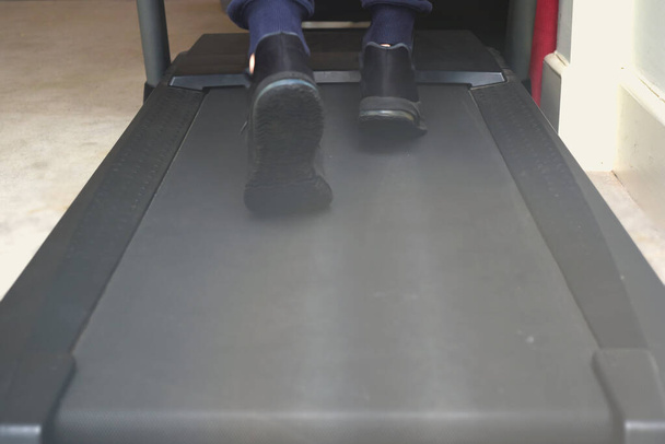 Mann trainiert zu Hause auf Laufband in umgebautem Fitnessraum im Haus - Foto, Bild