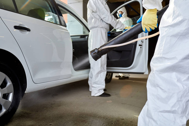 portrait of cleaners disinfecting the automobile - Fotó, kép