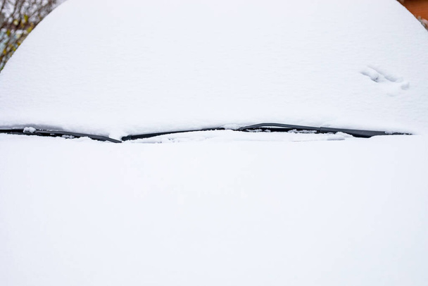 покрытый снегом капот автомобиля, естественный фон, первый снег - Фото, изображение