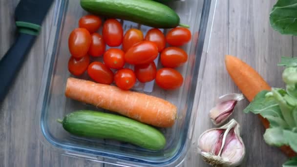 Καρότα, αγγούρι, ντομάτες, και περισσότερα λαχανικά σε ξύλινο τραπέζι - Πλάνα, βίντεο