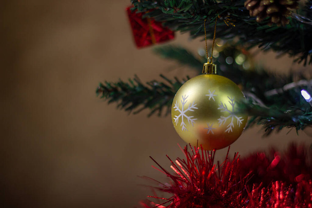 Árbol de Navidad decorado. Juguetes de Navidad de cerca. Decoraciones navideñas. Bola de Navidad de oro - Foto, imagen