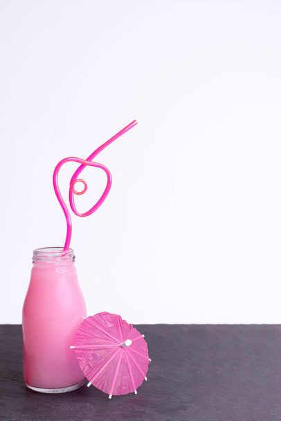 Üvegedény epres smoothie-val és szív alakú szívószállal - Fotó, kép