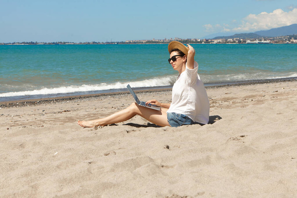 Mladá žena používající notebook na pláži. Dovolená životní styl komunikace. Koncept práce na volné noze - Fotografie, Obrázek
