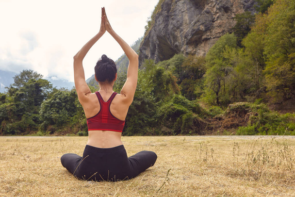 Yoga lessen in de natuur. Het concept van alleen sporten. Sociale uitsluiting. Een vrouw doet yoga in de bergen. - Foto, afbeelding