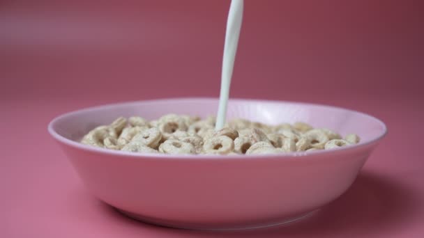 En cámara lenta, la leche vertiendo en un plato de anillos de cereales - Imágenes, Vídeo