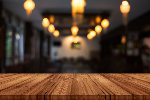Empty wooden table top with blurred coffee shop or restaurant interior background. can be used product display.  - Foto, Bild