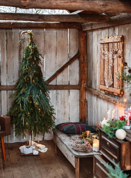 クリスマスとゼロ廃棄物、あなた自身の手でモミや枝で作られたクリスマスツリー、手作り。新年のテラスで素朴なスタイルのインテリアデザイン。手作り. - 写真・画像