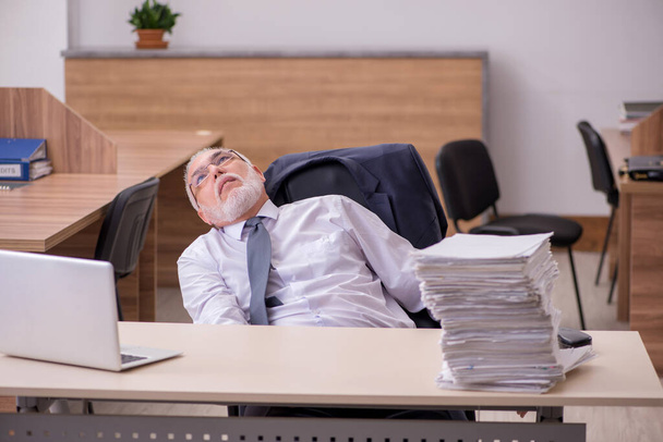 Viejo empleado descontento con el exceso de trabajo en la oficina - Foto, imagen