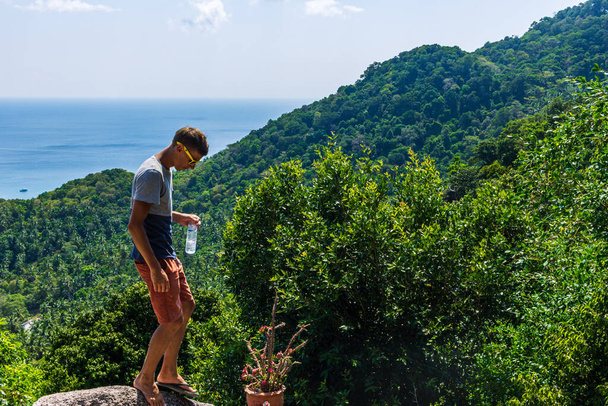 Man enjoy natural green panorama from Mango view point, visitor with water bottle - Foto, Imagem