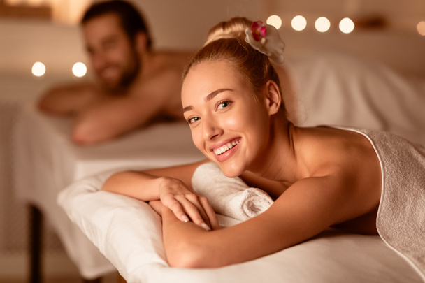 Woman At Couples Massage Smiling Lying On Bed At Spa - Foto, Imagen