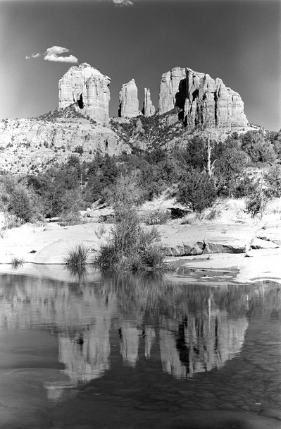 Catedral de roca con reflejos de agua en Oak Creek y una pequeña nube pasando bye. Red Rock Crossing área in Sedona, Arizona, USA. En blanco y negro. Cielo brumoso o prueba de un vórtice?  :)   - Foto, imagen