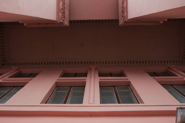 Historic building with pink stucco and columns. Architecture details - Фото, изображение