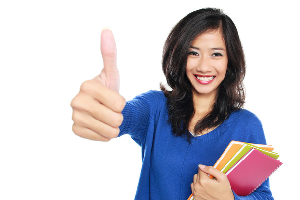 Young female student with books showing thumb up - Foto, immagini