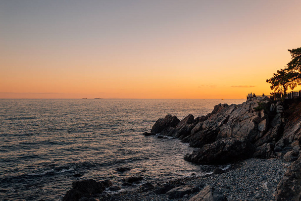 韓国・釜山の海雲台島と海の夕日 - 写真・画像