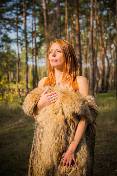 Redhead Scandinavian modern Viking woman, medieval atmosphere, attractive middle aged woman in furs - Photo, Image