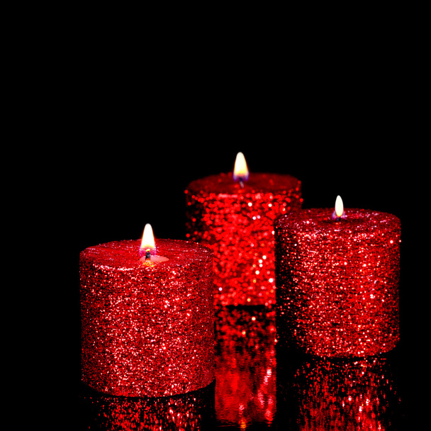 Três velas manchadas no escuro
 - Foto, Imagem