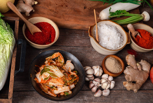 Φρέσκα υλικά και λαχανικά Τοποθετείται στο τραπέζι Για την παρασκευή Kimchi Το οποίο περιέχει συστατικά όπως τζίντζερ, σκόρδο, αλάτι, κρεμμύδι, ζάχαρη, gochugaru (κορεάτικο τσίλι). Το Κίμτσι είναι υγιεινό φαγητό.. - Φωτογραφία, εικόνα