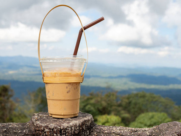 A glass of Thai tea on a mountain background in Khao Yai National Park - Photo, Image