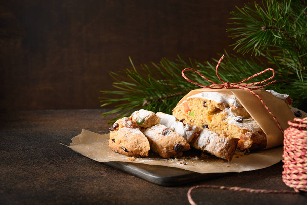 Christmas tasty stollen decorated holiday rope on brown table. Copy space. - Foto, afbeelding