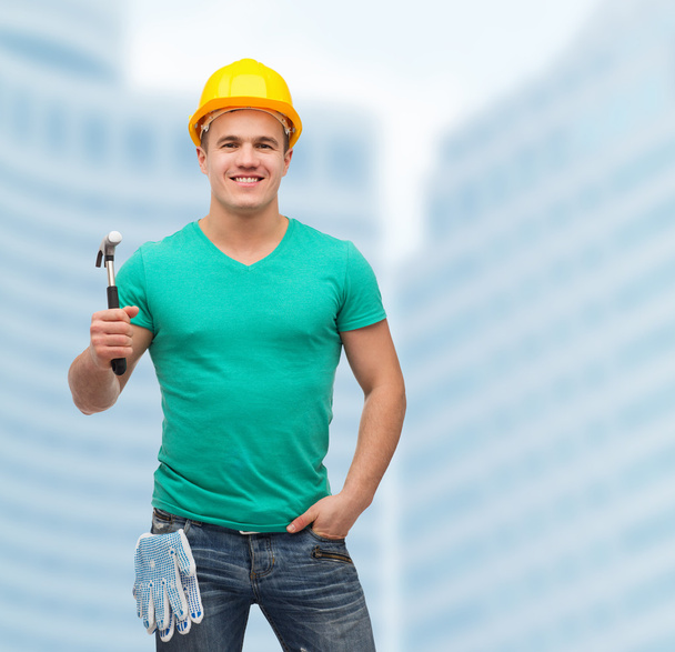 Smiling manual worker in helmet with hammer - Photo, image