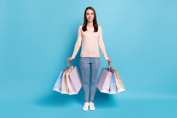 Full length body size view of her she nice attractive pretty cheerful cheery brown-haired girl carrying new things commerce retail isolated bright vivid shine vibrant blue color background - Foto, afbeelding