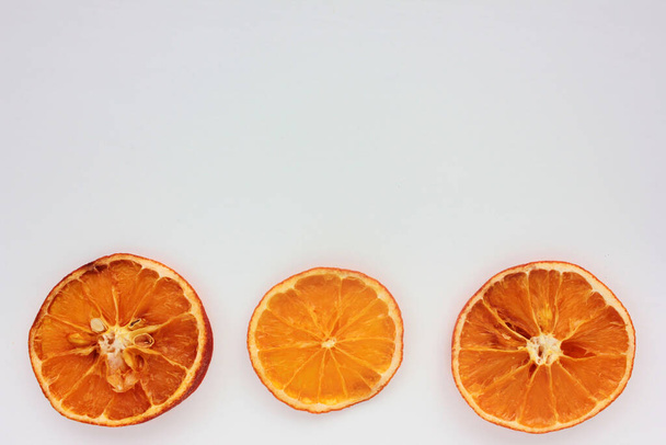 Dried oranges on white background. Flat lay Christmas border. Copy space - Photo, Image