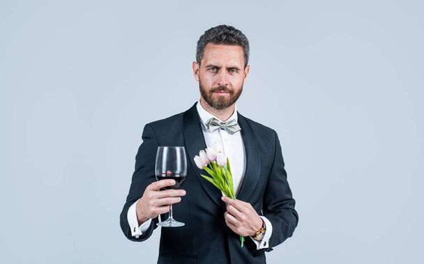 cheers for valentines day. alcohol drinking. handsome male on romantic date. professional bartender on formal event. man with wine glass. skilled barman. sommelier. guy drink wine. Cheers to friends - Photo, Image