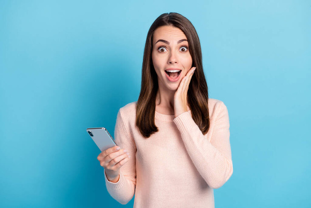 Portrait of her she nice attractive pretty cheerful cheery amazed brown-haired girl using device great win luck notification app isolated on bright vivid shine vibrant blue color background - Foto, afbeelding