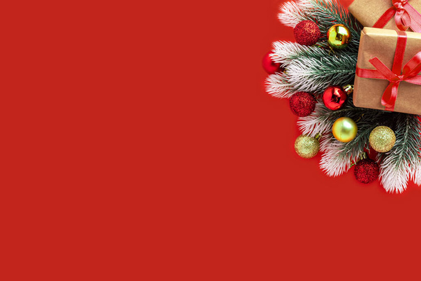 Christmas decoration gifts present box, fir tree branches, balls on red background. new year - Foto, Imagen