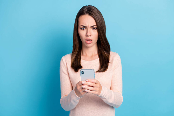 Photo of shocked girl read social media information on cellphone wear pastel clothes isolated over blue color background - Фото, зображення