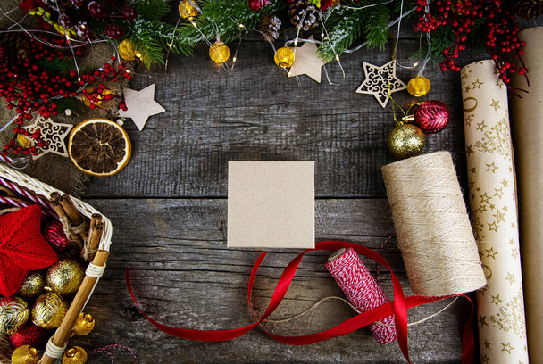 Flat lay packaging of Christmas gifts on wooden background. Gift box and red ribbon. - 写真・画像
