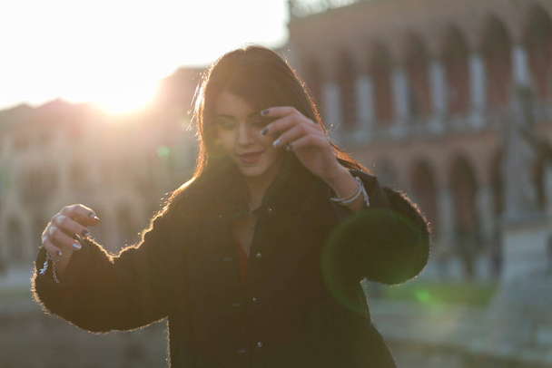 kaunis tyttö pitkät Välimeren mustat hiukset auringonlaskun aukiolla Padovan. Laadukas kuva - Valokuva, kuva