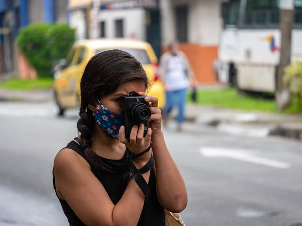 Junge hispanische Frau macht ein Foto mit Kamera - Foto, Bild
