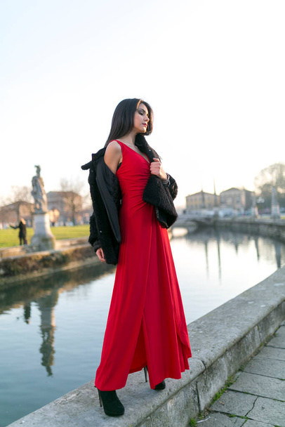bella ragazza con lunghi capelli neri in piedi sul bordo del canale nella piazza di Padova. Foto di alta qualità - Foto, immagini