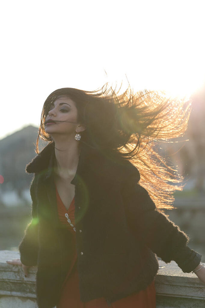 beautiful girl with long mediterranean black hair at sunset in the square of padua. High quality photo - Фото, зображення