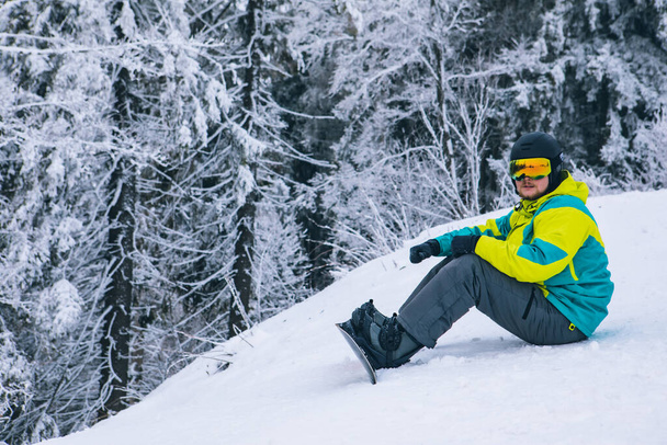man strap in snowboard. winter sport activities. ski resort - Photo, Image